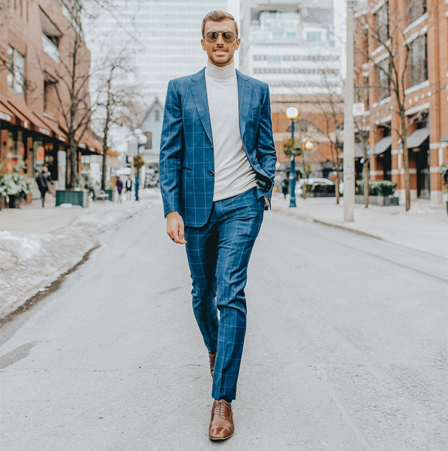 Erik Paige walking down a downtown street in a blue suit
